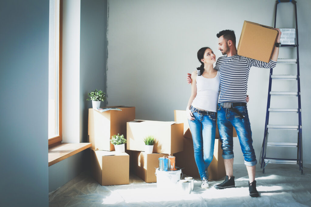 Your Eco-Friendly Moving Guide with Flexistore Self-Storage 4 Happy young couple unpacking or packing boxes and moving into a new home.