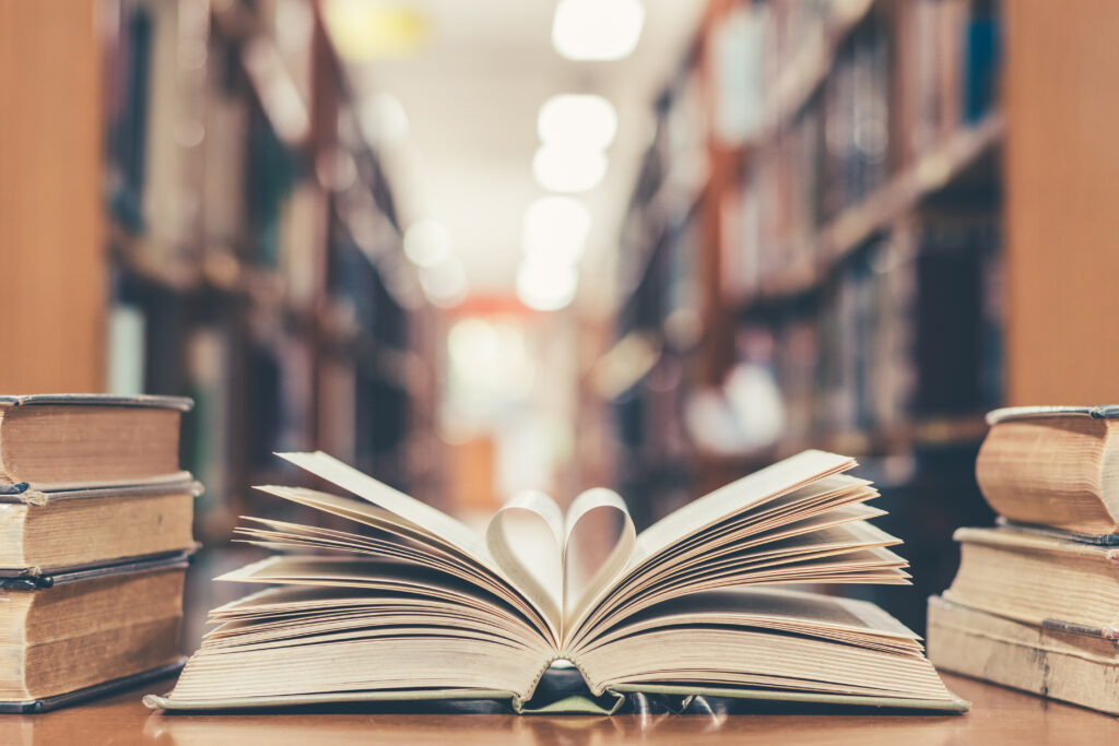 Self-Storage for Students in South Africa: Affordable Solutions for University Breaks 2 Love story book with open page of literature in heart shape and stack piles of textbooks on reading desk in library study room for education learning, and national library lovers month concept